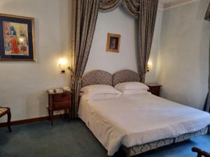 a hotel room with a bed and two lamps at PHI Hotel Canalgrande in Modena