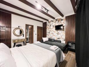 une chambre d'hôtel avec un lit et un canapé dans l'établissement Boutique Plakias Guesthouse ex Boutique Holy Spirit, à Kalambaka