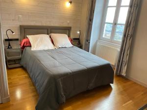 a large bed in a room with a large window at Auberge De Margot in Usson