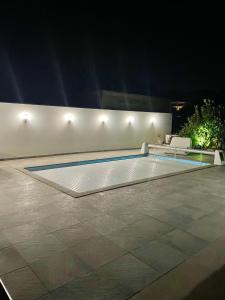 een zwembad in het midden van een patio 's nachts bij Villa de 3 chambres avec piscine privee jacuzzi et jardin clos a Porto Vecchio in Porto-Vecchio