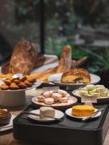 uma mesa com diferentes tipos de alimentos em pratos em Balthazar Hôtel & Spa Rennes - MGallery Hotel Collection em Rennes