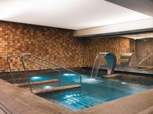 a hot tub with a water fountain in a building at Balthazar Hotel & Spa - MGallery by Sofitel in Rennes