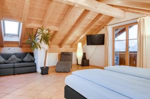 1 dormitorio con cama, sofá y TV en Ferienwohnung mit Bergblick en Unterammergau