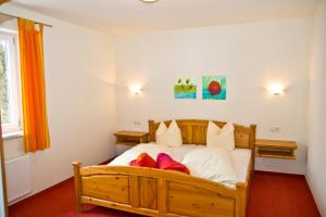 a bedroom with a wooden bed with red shoes on it at Appartmentanlage Isegrim in Altenmarkt im Pongau +8 photos