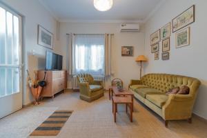 ein Wohnzimmer mit einem Sofa und einem TV in der Unterkunft Vintage-style Garden Apartment in Athen