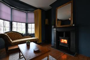 a living room with a fireplace and a mirror at Opulent Georgian townhouse overlooking Spencer Square in Kent
