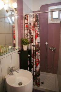 La salle de bains est pourvue d'un rideau de douche et d'un lavabo. dans l'établissement Hotel Karagianni, à Vólos