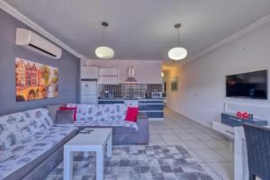 a living room with a couch and a kitchen at Dalyan Elit Apart Otel in Çeşme
