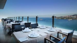 un restaurante con mesas y sillas y vistas al océano en Dedeman Zonguldak, en Zonguldak