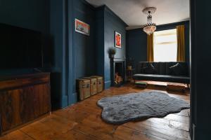 KentにあるOpulent Georgian townhouse overlooking Spencer Squareのリビングルーム(青い壁、床に敷物付)