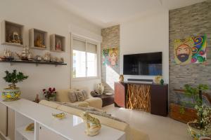 ein Wohnzimmer mit einem Sofa und einem TV in der Unterkunft Hotel Jonio in Noto Marina