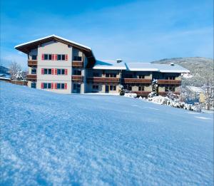 a house on top of a snow covered hill at Appartmentanlage Isegrim in Altenmarkt im Pongau