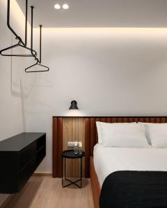 een slaapkamer met een bed, een nachtkastje en 2 verlichting bij Acropolis White Key Residence in Athene