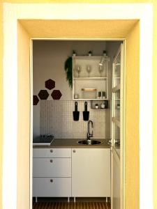 a kitchen with white cabinets and a sink at Castello Attic Sunset in Cagliari