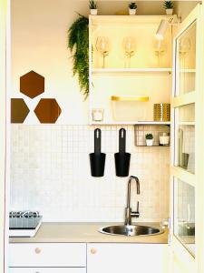 a kitchen with a sink and wine glasses on the wall at Castello Attic Sunset in Cagliari