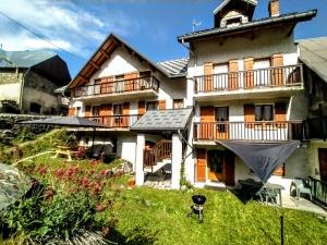 a large house with a balcony and a yard at Résidence Le Martinan in Saint-Colomban-des-Villards