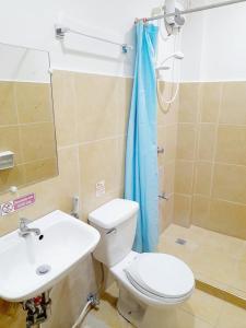 a bathroom with a toilet and a sink and a shower at Park Avenue Residence Inn and Suites in Davao City