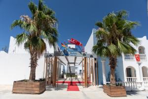 a building with two palm trees in front of it at Dreams Bodrum butik hotel in Bodrum City