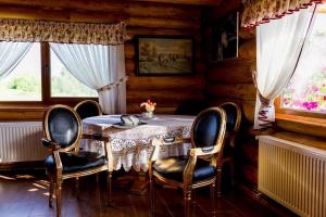 Un comedor con mesa y sillas y ventanas. en Cabana Popasul Calaretului, en Râșnov 23 fotos más