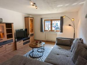 ein Wohnzimmer mit einem Sofa und einem Tisch in der Unterkunft Landhaus GLÜCKSmoment in Rottau
