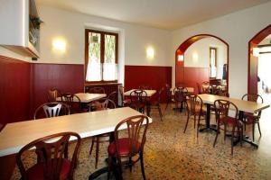 a restaurant with tables and chairs in a room at Albergo Maccagno in Maccagno Inferiore