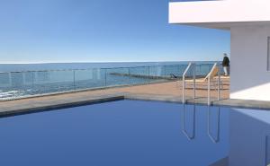 a swimming pool with a view of the ocean at Hotel Ariston in Caorle