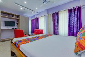 um quarto de hotel com uma cama e uma televisão em FabHotel New Central em Bhubaneshwar