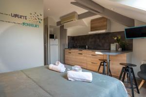 a bedroom with two towels on a bed with a kitchen at Residence Croma in La Roche-Posay