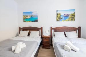 2 Betten in einem Zimmer mit weißer Bettwäsche in der Unterkunft Villa Dolphin by Slow Villas in Sa Ràpita
