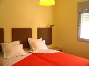 1 dormitorio con 1 cama con manta roja y almohadas en TLV Living Apartment, en Tel Aviv