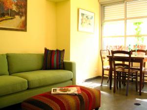 a living room with a green couch and a table at TLV Living Apartment in Tel Aviv