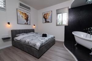 a bedroom with a bed and a bath tub at Luxury Room Bahai's Garden in Haifa