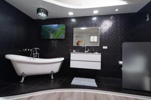 Baño negro con bañera y lavamanos en Luxury Room Bahai's Garden en Haifa