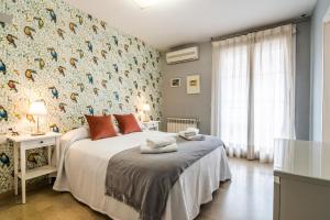 - une chambre avec un lit orné d'un mur fleuri dans l'établissement tuGuest Grisolia House, à Armilla