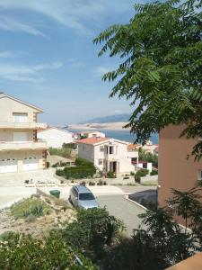 a car parked in a parking lot next to a building at Apartman Olja in Pag