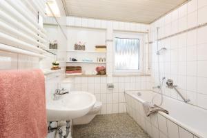 a bathroom with a sink and a tub and a toilet at Zweistapfenweg 9a in Oberstdorf +21 photos