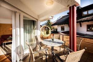a patio with a table and chairs on a balcony at Zweistapfenweg 9a in Oberstdorf