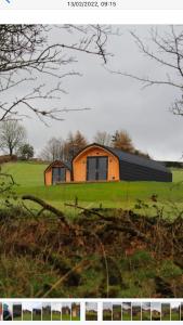 ein Haus auf einem grünen Feld mit einem Haus in der Unterkunft Fox's Den in Bathgate