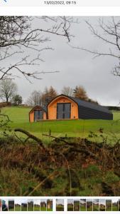 a house on a green field with a house at Fox's Den in Bathgate