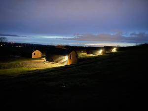 een groep schuren in een veld 's nachts bij Fox's Den in Bathgate