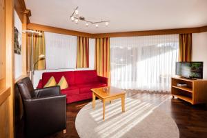 a living room with a red couch and a table at Zweistapfenweg 9a in Oberstdorf