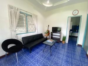 sala de estar con sofá negro y mesa en Karon house 15A, en Karon Beach