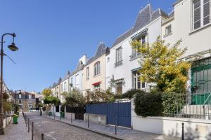 Une rangée de maisons blanches dans une rue dans l'établissement Comfortable house with terrace for 5 people by Wee, à Paris