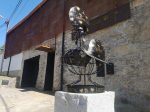 uma estátua de um capacete em frente a um edifício em Leonchic - Guest House com Piscina de Água Salgada em Barcelos