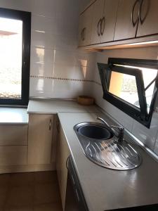 una piccola cucina con lavandino e finestra di CASA ORILLA! Beautiful private holiday villa with hot tub a La Oliva
