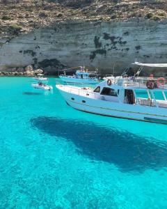 una barca è ormeggiata nell'acqua blu di RgB_Apartments a Lampedusa