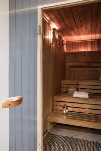 a bathroom with a shower with a wooden bench at Scandic Gdańsk in Gdańsk