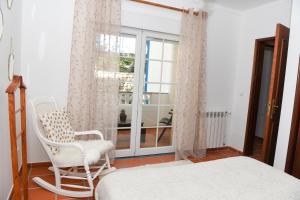 a bedroom with a bed and a chair and a window at The Quiet Loft Praia d'el Rey Golf Resort in Amoreira +14 photos
