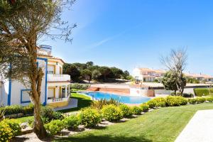 a villa with a swimming pool in a yard at The Quiet Loft Praia d'el Rey Golf Resort in Amoreira