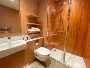 a bathroom with a shower and a toilet and a sink at Hex Wildlife Hotel at Yorkshire Wildlife Park in Doncaster